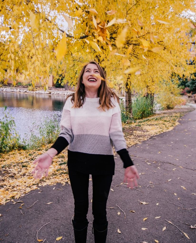 Throwing fall leaves in the air in Breckenridge - one of the best fall activities in Colorado