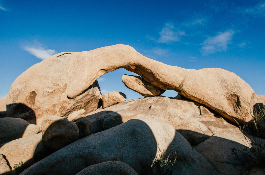 The stone arch of Arch Rock with the blue sky behind and above the arch.