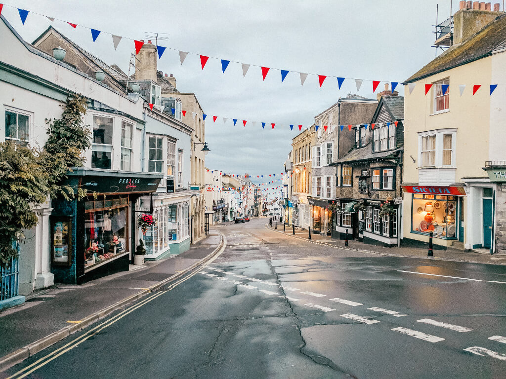 Main street in Lyme Regis with red, white, and blue streamers over the street