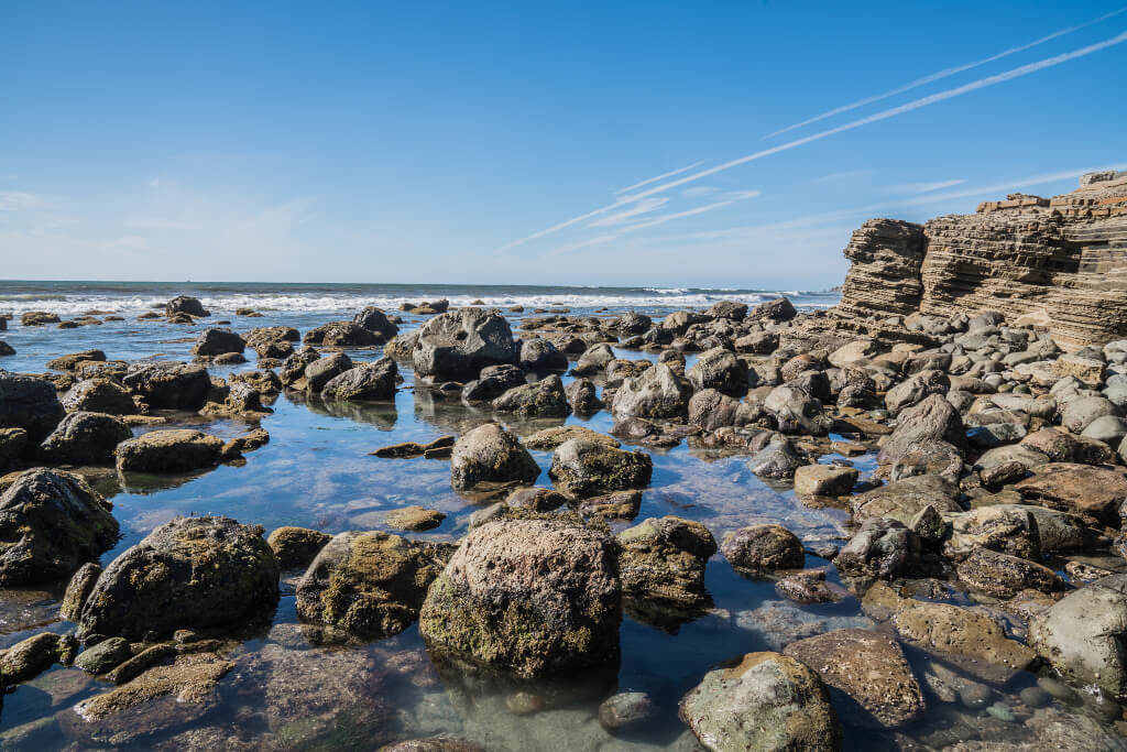Rocky tide pools at Cabrillo National Park looking out over the ocean and the blue sky