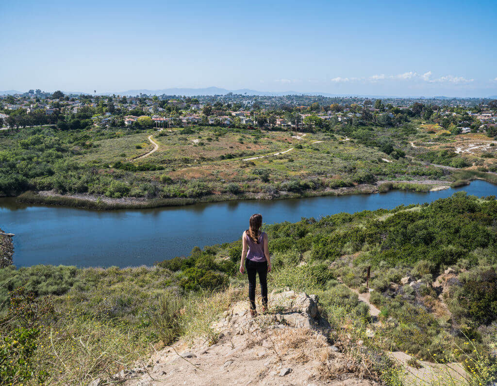 Girl standing on mountaintop overlooking Lake Calavera