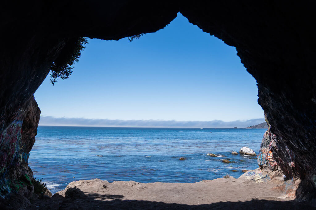 View of the ocean framed with the dark walls of Smugglers Cave