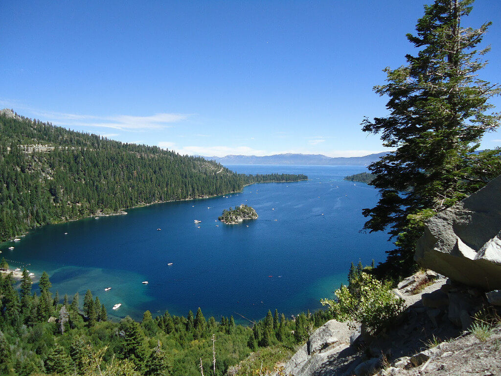 Blue lake of Lake Tahoe with green trees surrounding it