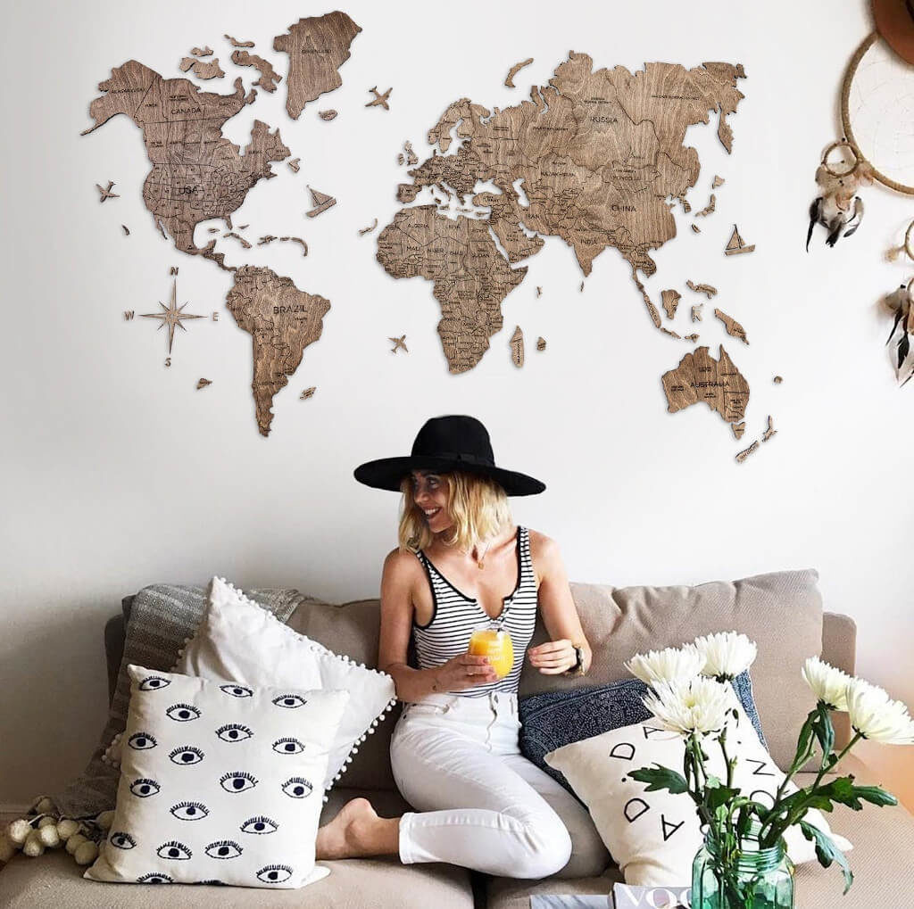 Girl sitting on couch with wooden travel map on wall behind