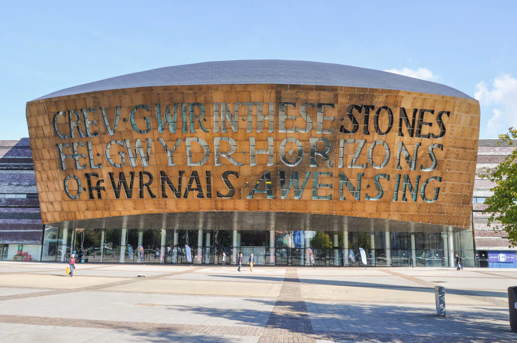 Front of the Millennium Centre in Cardiff, Wales that reads "In these stones horizons sing" in both English and Welsh